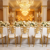 Gold radial spider web backrest chairs at wedding banquet hall table chandeliers column legs