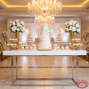 Silver rectangular dessert table at wedding tiered cake macarons florals crystal chandeliers