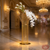 Gold tall oval ball cage column stand side view wedding venue warm uplighting marble reflection