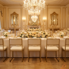 Gold floating backrest chairs at hotel banquet hall long dinner table chandeliers cream leather