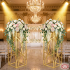 Gold diagonal mesh columns flanking hotel wedding stage florals theatrical spotlights 45 degree