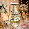Gold birdcage gourd display stand at luxury wedding dessert table flowers cake golden lighting