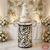 White black rose cylinder cake stand with tiered wedding cake white florals gold backdrop