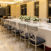 Silver X-cross rosette chairs at modern luxury hotel restaurant dinner table chandeliers