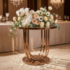 Rose gold curved slat cage stand at hotel wedding 45 degree vertical slats warm spotlights