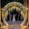 Silver round arch as grand wedding venue entrance decorated white flowers warm golden lighting
