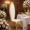 Gold crown banquet chair at luxury hotel suite dining room floral arrangement warm golden lighting