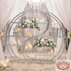 Silver moon gate double ring rack at wedding ceremony space florals candles crystal bokeh