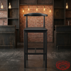 Matte black industrial bar stool at hotel bar exposed brick Edison bulb lighting