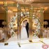 Gold Art Deco arch at luxury wedding ceremony couple beneath arch floral garlands crystal chandeliers