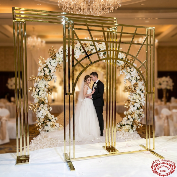 Gold Art Deco arch at luxury wedding ceremony couple beneath arch floral garlands crystal chandeliers