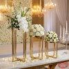 Gold round pedestal stands at hotel wedding reception cross-fretwork base florals 45 degree