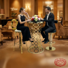 Gold bar table 2 stools set at upscale hotel VIP lounge guests seated warm amber golden tones