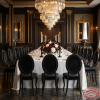 All-black oval velvet chairs at upscale hotel restaurant dark wedding dinner table chandeliers
