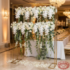 Gold standing frame at hotel wedding reception as floral backdrop hanger roses orchids 45 degree