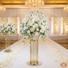 Gold oval ball top cage column stands flanking wedding aisle white floral balls rose petals chandeliers