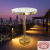 Gold round cocktail table at upscale hotel rooftop bar city skyline dusk