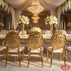 Gold round rose embossed backrest chairs at wedding banquet hall dinner table chandeliers