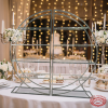 Silver circular wine rack at romantic wedding dessert table with fairy lights