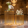 Gold U-arc tube stands side view ballroom two heights arc shadows warm uplighting marble