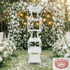 White vase pillar shelf at outdoor garden wedding white florals fairy lights bokeh
