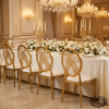 Gold radial arc backrest chairs showing ornate back detail at banquet hall chandeliers