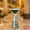Silver funnel cocktail table at grand luxury hotel lobby marble staircase golden lighting