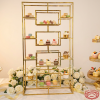 Gold staggered display rack at elegant wedding dessert table white roses gold ribbon