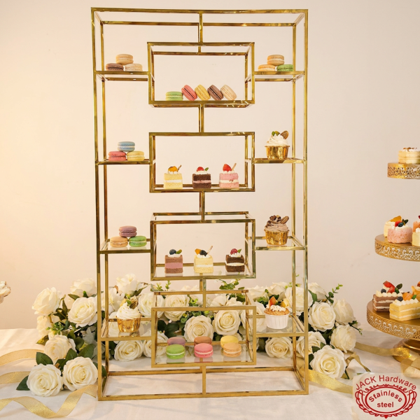 Gold staggered display rack at elegant wedding dessert table white roses gold ribbon