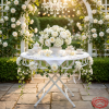 White iron lattice folding table at wedding garden party florals tea settings romantic backdrop