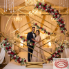 Gold geometric circle arch as hotel ballroom wedding photo backdrop rose garlands chandelier bokeh