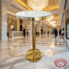 Gold round cocktail table at luxury 5-star hotel grand lobby marble floors crystal chandelier