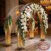 Silver fan arch as grand wedding venue entrance floral decorated warm golden lighting side view