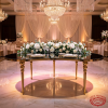 Gold ball-node round banquet table at hotel ballroom head table uplighting cascading rose garland marble