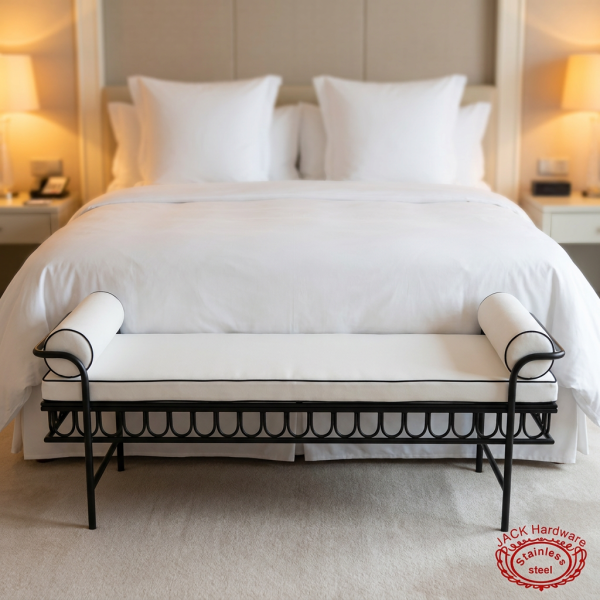 Black iron scrollwork white bench at luxury 5-star hotel suite foot of king bed white linen warm lighting