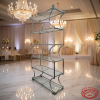 Silver multi-tier glass display rack at elegant hotel event space marble floors crystal chandeliers