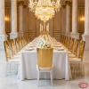 Gold mirror backrest white leg chairs at grand hotel banquet hall dinner table chandeliers