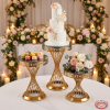 Gold 3-piece cake stand set at wedding dessert display tiered cake macarons floral bokeh candlelight