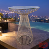 Rose gold cocktail table at upscale hotel rooftop terrace city skyline dusk