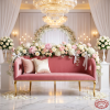 Rose pink loveseat at wedding venue bridal seat white florals crystal chandeliers marble