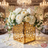 Gold bubble cutout box with white roses peonies overflowing chandelier light circles on marble