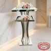 Silver two-tier service stand at hotel spa suite entrance white orchids roses soft lighting
