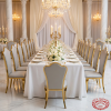 Gold crown wave-top chairs at elegant wedding hotel banquet table chandeliers grey leather