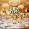 Gold calligraphy number standees as table markers at luxury wedding banquet florals chandeliers