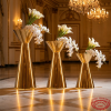 Gold double-trumpet 3 stands side view grand ballroom cascading heights uplighting marble reflections