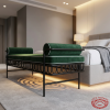 Black iron scrollwork side panel bed end bench side view hotel bedroom warm light grey carpet shadows