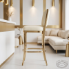 Gold cream upholstered stool at modern boutique hotel lounge gold white interior
