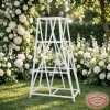 White X-cross display rack at outdoor garden wedding white floral backdrop bokeh