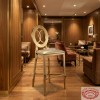 Gold ring backrest bar stool at boutique hotel lounge warm walnut wood gold brass accents