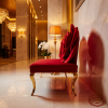 Red rose sculptural sofa side view hotel lobby bold artistic statement warm amber lighting